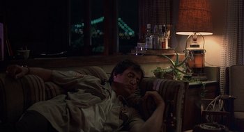 Movie still from “Cop Land” (1997), directed by James Mangold – A man laying on a couch in a living room at night; Medium shot, Low angle