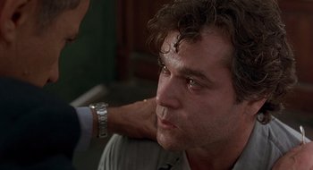 Movie still from “Cop Land” (1997), directed by James Mangold – A person with a hand on a mans shoulder; Close Up shot, Over the shoulder angle
