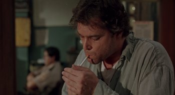Movie still from “Cop Land” (1997), directed by James Mangold – A man with a beard is holding a straw; Close Up shot, Low angle