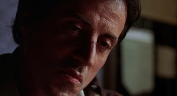 Movie still from “Cop Land” (1997), directed by James Mangold – A man's face in a dark room; Close Up shot, Low angle