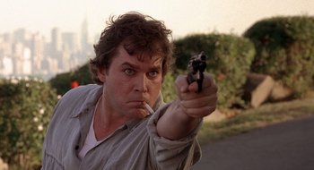 Movie still from “Cop Land” (1997), directed by James Mangold – A man is holding a gun and smoking a cigarette; Close Up shot, Low angle