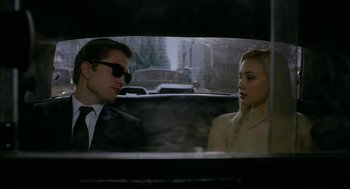 Movie still from “Cosmopolis” (2012), directed by David Cronenberg – A man and a woman sitting in the back of a car; Medium shot, Over the shoulder angle