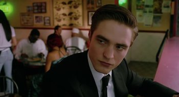 Movie still from “Cosmopolis” (2012), directed by David Cronenberg – A person wearing a suit and tie; Close Up shot, Over the shoulder angle