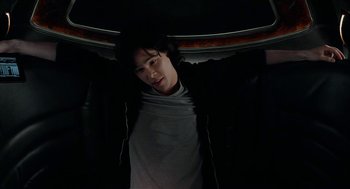 Movie still from “Cosmopolis” (2012), directed by David Cronenberg – A man in a white shirt and black jacket; Medium shot, Overhead angle