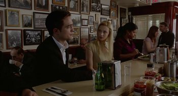 Movie still from “Cosmopolis” (2012), directed by David Cronenberg – A man and a woman sitting at a table; Medium shot, Over the shoulder angle