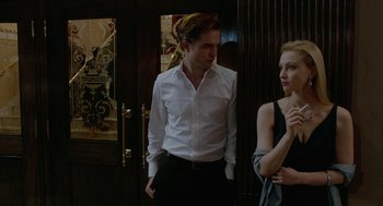 Movie still from “Cosmopolis” (2012), directed by David Cronenberg – A man and a woman standing next to each other in front of a door; Medium shot, Over the shoulder angle