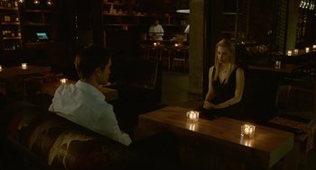 Movie still from “Cosmopolis” (2012), directed by David Cronenberg – A man and a woman sitting at a table in front of a candle; Medium shot, Over the shoulder angle