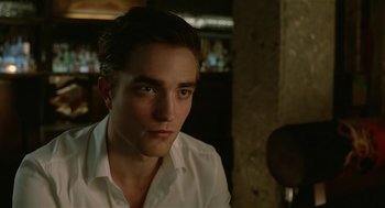 Movie still from “Cosmopolis” (2012), directed by David Cronenberg – A person wearing a white shirt; Close Up shot, Over the shoulder angle
