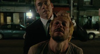 Movie still from “Cosmopolis” (2012), directed by David Cronenberg – Two men in suits and ties one of them is a man with a beard and the other is a man with blond hair and a beard; Close Up shot, Over the shoulder angle