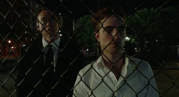 Movie still from “Cosmopolis” (2012), directed by David Cronenberg – A man in a white shirt and a man in a black tie; Medium shot, Over the shoulder angle