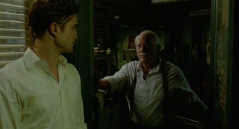 Movie still from “Cosmopolis” (2012), directed by David Cronenberg – A man in a white dress shirt and a man in a white dress shirt and tie; Medium shot, Over the shoulder angle