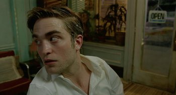 Movie still from “Cosmopolis” (2012), directed by David Cronenberg – A person wearing a white shirt; Close Up shot, High angle