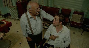 Movie still from “Cosmopolis” (2012), directed by David Cronenberg – An older man and a younger man are having a conversation; Medium shot, Over the shoulder angle
