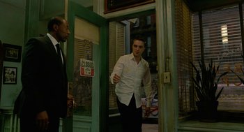 Movie still from “Cosmopolis” (2012), directed by David Cronenberg – A man in a white dress shirt and a black tie; Medium shot, Over the shoulder angle