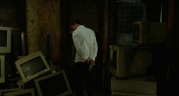 Movie still from “Cosmopolis” (2012), directed by David Cronenberg – A man standing in a room holding a knife; Wide shot, Low angle