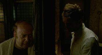 Movie still from “Cosmopolis” (2012), directed by David Cronenberg – A man standing next to another man in front of a mirror; Medium shot, Over the shoulder angle