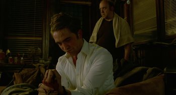 Movie still from “Cosmopolis” (2012), directed by David Cronenberg – A man sitting in front of another man in a room; Medium shot, Over the shoulder angle