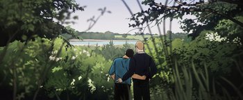 Movie still from “Flee” (2021), directed by Jonas Poher Rasmussen – Two men are looking out over a lake; Wide shot, High angle
