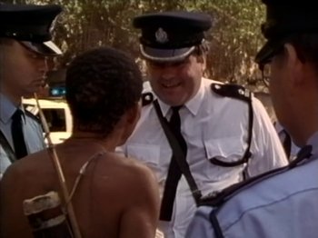 Movie still from “Crazy Hong Kong” (1993), directed by Wellson Chin – A man in a police uniform talking to some people; Medium shot, Over the shoulder angle