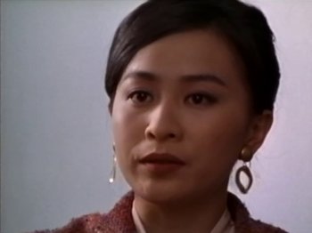 A person wearing a jacket and earrings