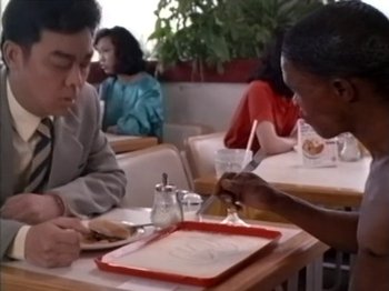 Two people sitting at a table with a tray of food in front of them