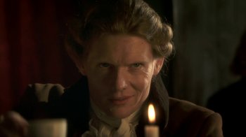 Movie still from “Crooked House” (2017), directed by Gilles Paquet-Brenner – A woman with a candle in a dark room; Close Up shot, Over the shoulder angle