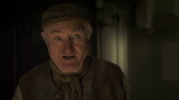 Movie still from “Crooked House” (2017), directed by Gilles Paquet-Brenner – An older man with a hat and a scarf on; Close Up shot, Low angle