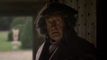 Movie still from “Crooked House” (2017), directed by Gilles Paquet-Brenner – An old man wearing a hat and a coat; Close Up shot, Over the shoulder angle