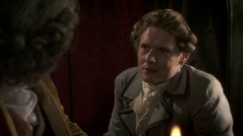 Movie still from “Crooked House” (2017), directed by Gilles Paquet-Brenner – A man in a suit is looking at another man; Close Up shot, Over the shoulder angle