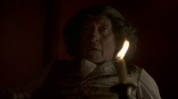 Movie still from “Crooked House” (2017), directed by Gilles Paquet-Brenner – An old man holding a lit candle in a dark room; Close Up shot, Over the shoulder angle