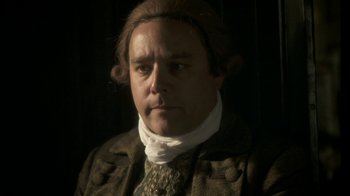 Movie still from “Crooked House” (2017), directed by Gilles Paquet-Brenner – A person wearing a suit and tie; Close Up shot, High angle