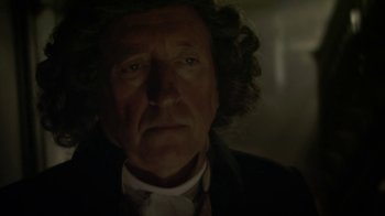Movie still from “Crooked House” (2017), directed by Gilles Paquet-Brenner – An old man with curly hair and a white beard; Close Up shot, Over the shoulder angle