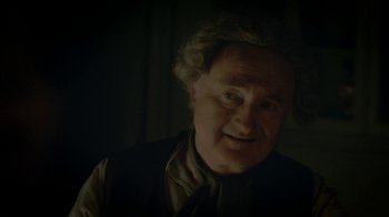 Movie still from “Crooked House” (2017), directed by Gilles Paquet-Brenner – An old man with a beard and a tie; Close Up shot, Over the shoulder angle