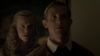 Movie still from “Crooked House” (2017), directed by Gilles Paquet-Brenner – A man and a woman standing next to each other in a room; Close Up shot, Low angle