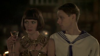 Movie still from “Crooked House” (2017), directed by Gilles Paquet-Brenner – A man and a woman standing next to each other; Close Up shot, Over the shoulder angle