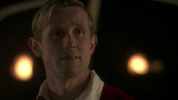 Movie still from “Crooked House” (2017), directed by Gilles Paquet-Brenner – A person wearing a red shirt; Close Up shot, Over the shoulder angle