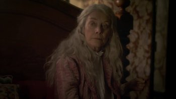 Movie still from “Crooked House” (2017), directed by Gilles Paquet-Brenner – An old woman with long white hair and a pink jacket; Close Up shot, Over the shoulder angle