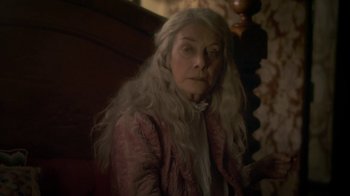 Movie still from “Crooked House” (2017), directed by Gilles Paquet-Brenner – An older woman with long white hair sitting on a chair; Close Up shot, High angle