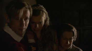 Movie still from “Crooked House” (2017), directed by Gilles Paquet-Brenner – A group of people standing next to each other in a dark room; Close Up shot, Over the shoulder angle