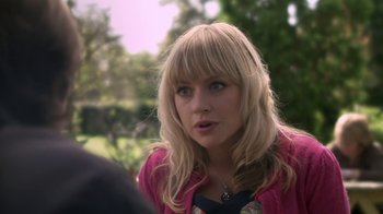 Movie still from “Crooked House” (2017), directed by Gilles Paquet-Brenner – A woman with blonde hair and a pink jacket; Close Up shot, Over the shoulder angle
