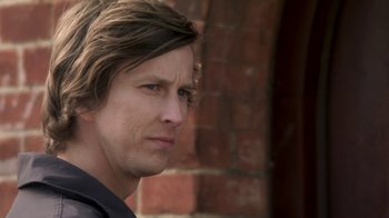 Movie still from “Crooked House” (2017), directed by Gilles Paquet-Brenner – A person with long brown hair; Close Up shot, Over the shoulder angle