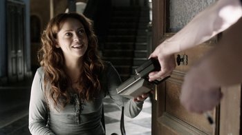 Movie still from “Curse of Chucky” (2013), directed by Don Mancini – A woman is smiling while a man opens a door; Medium shot, Over the shoulder angle