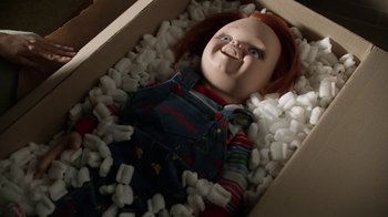 Movie still from “Curse of Chucky” (2013), directed by Don Mancini – A chucky doll is in a box of styrofoam; Medium shot, Overhead angle