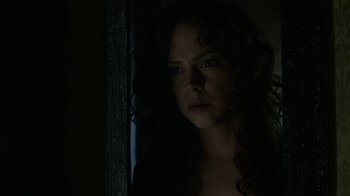 Movie still from “Curse of Chucky” (2013), directed by Don Mancini – A woman with long curly hair looking out a window; Close Up shot, Over the shoulder angle