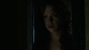 Movie still from “Curse of Chucky” (2013), directed by Don Mancini – A person with curly hair in a dark room; Close Up shot, Over the shoulder angle