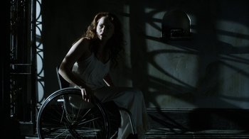 Movie still from “Curse of Chucky” (2013), directed by Don Mancini – A woman sitting in a wheel chair in a dark room; Medium shot, Low angle