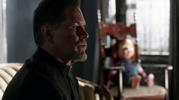 Movie still from “Curse of Chucky” (2013), directed by Don Mancini – A man sitting in front of a chucky doll; Close Up shot, Over the shoulder angle