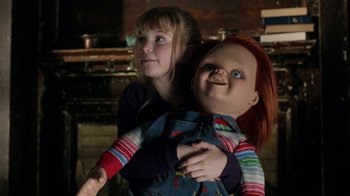 Movie still from “Curse of Chucky” (2013), directed by Don Mancini – A little girl holding onto a chucky doll; Medium shot, Overhead angle