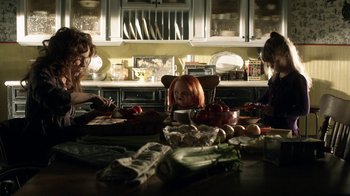Movie still from “Curse of Chucky” (2013), directed by Don Mancini – Three people sitting at a table with vegetables; Medium shot, High angle