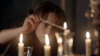 Movie still from “Curse of Chucky” (2013), directed by Don Mancini – A woman lighting a candle in a candle holder; Close Up shot, Over the shoulder angle
